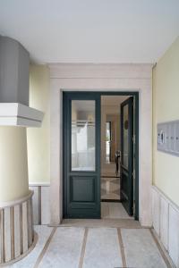 una porta verde in una stanza con corridoio di Piazza Duomo Guest House ad Ariano Irpino