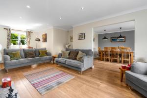 een woonkamer met 2 banken en een eetkamer bij Woodside Cottage in Chipping Campden