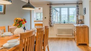 een keuken en eetkamer met een tafel en stoelen bij Woodside Cottage in Chipping Campden