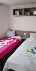 zwei Betten nebeneinander in einem Zimmer in der Unterkunft Mobil home famille Calazel in Sérignan