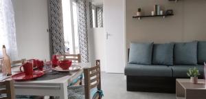 ein Wohnzimmer mit einem Tisch und einem Sofa in der Unterkunft Mobil home famille Calazel in Sérignan