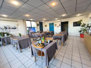 a restaurant with tables and chairs in a room at Hôtel Le Laury's-hôtel calme proche de Rodez avec parking privé gratuit-Arrivée après 20h possible via borne automatique in Onet le Château