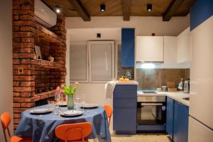 a kitchen with a table with orange chairs and blue cabinets at Balkan Charm - Private Parking in Belgrade