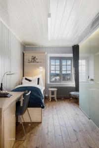 una camera da letto con un letto, una scrivania e una scrivania di Kongsvinger Castle Hotel & Resort a Kongsvinger