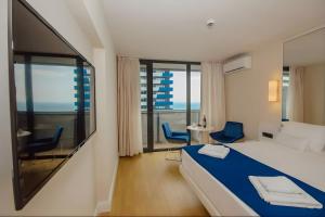 een hotelkamer met een bed en twee stoelen bij Wavescape Residences Orbi City Batumi in Batoemi +193 foto's