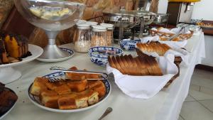 a table with plates of food and a glass of wine at Pousada Agua Viva in Abraão