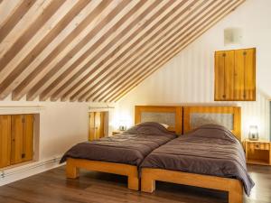 Schlafzimmer mit einem Bett und Holzdecken in der Unterkunft Mas de la Barque in Gourdouze