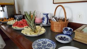 a table with plates and bowls of fruit on it at Pousada Agua Viva in Abraão