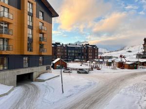 a snow covered street in front of a building at New Gudauri Redco F1 in Gudauri