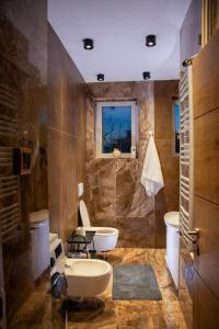 a bathroom with a sink and two toilets at Balkan Charm - Private Parking in Belgrade