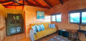 a living room with a yellow couch in a wooden wall at 7 on Kloof in Mossel Bay