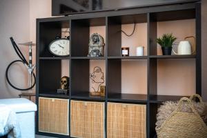 a black book shelf with a clock on it at Apartment Angel's Nest with Sauna and Fitness in Jesenice