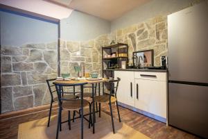 a kitchen with a table and chairs and a stone wall at Apartment Angel's Nest with Sauna and Fitness in Jesenice +27 photos