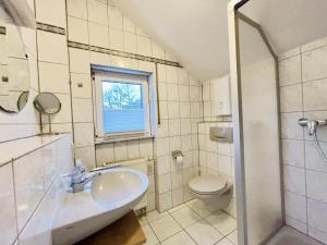 a bathroom with a sink and a toilet and a window at Ferienwohnungen Weingut Breit in Piesport +30 photos
