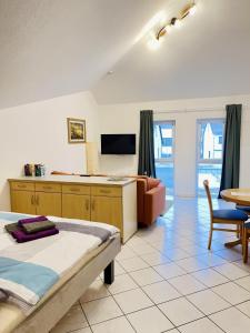a room with a bed and a couch and a tv at Ferienwohnungen Weingut Breit in Piesport