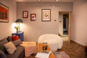 a living room with a couch and a table at Balkan Charm - Private Parking in Belgrade +21 photos