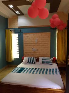 una camera da letto con un grande letto con palloncini rossi sul soffitto di Monique CZ Abomey Plage ad Abomey