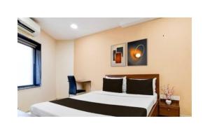 ein Hotelzimmer mit einem Bett und einem Stuhl in der Unterkunft Gokul Residency in kolkata