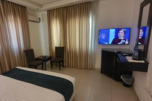 a hotel room with a bed and a flat screen tv at Jordan View Hotel in Amman