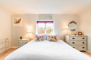 En eller flere senge i et værelse på Willow Cottage by Leap Escapes