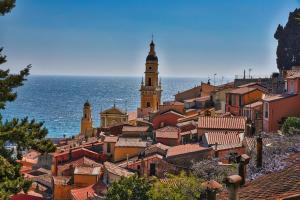 a view of a town with a church and the ocean at Hôtel Claridge's in Menton