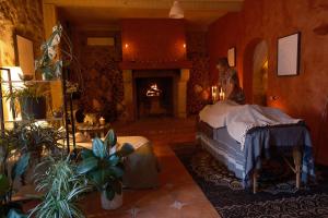 a man standing in a room with a bed and a fireplace at Divas Upes SPA hotel Koknese in Koknese
