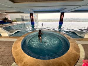 a woman is standing in a swimming pool at Phương hotel Lyn Time Thanh Thuỷ in La Phu