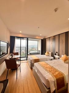 a hotel room with two beds and a desk at Phương hotel Lyn Time Thanh Thuỷ in La Phu