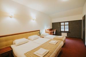 a hotel room with two beds and a piano at Zamek Bożejów - Kuźnia in Radomierowice