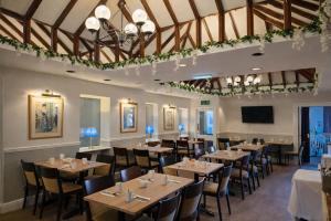a restaurant with tables and chairs and a flat screen tv at The County Hotel in Carlisle