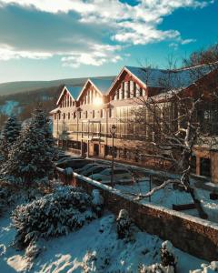 a large building with snow on the ground at Hotel & Medi-Spa Biały Kamień in Świeradów-Zdrój