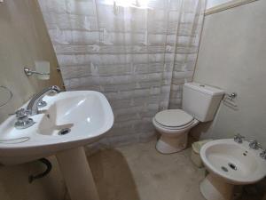 een witte badkamer met een wastafel en een toilet bij Escalera de piedra 2 in Tilcara