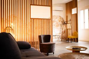 een woonkamer met een bank en een stoel bij Bordeaux Suites & Spa in Bordeaux