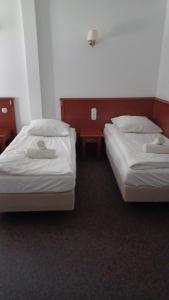 two beds in a hotel room with two tables at Zamek Bożejów - Kuźnia in Radomierowice
