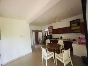een keuken en eetkamer met een tafel en stoelen bij Goyambokka Beach front pool resort in Tangalle