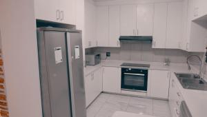 a kitchen with white cabinets and a stainless steel refrigerator at DC Guest House in Avondale