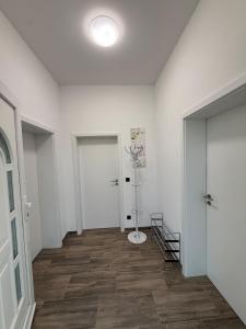 einen Flur mit weißen Wänden, Holzböden und einer Tür in der Unterkunft Moderner Neubau nähe Lübeck in Stockelsdorf + 7 Fotos