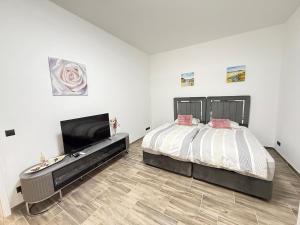 a bedroom with a bed and a flat screen tv at Moderner Neubau nähe Lübeck in Stockelsdorf