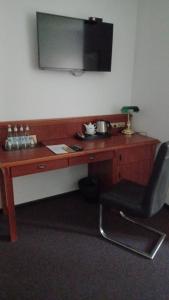 a wooden desk with a chair and a television on a wall at Zamek Bożejów - Kuźnia in Radomierowice