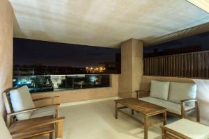 a balcony with a couch and chairs and a table at Prestigia 16 in Marrakesh