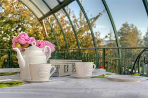 a table with two cups and a vase with flowers at Residenza Guglielmi in Campobasso