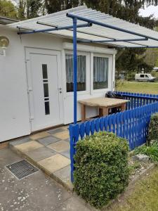 a small house with a blue fence and a table at Ferienbungalow Fleesensee in Malchow