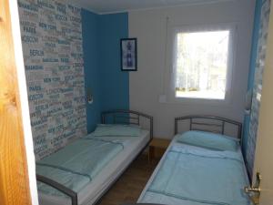 two beds in a small room with a window at Ferienbungalow Fleesensee in Malchow
