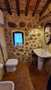 a stone bathroom with a toilet and a sink at L'Ottava Goccia Country House in Tolfa