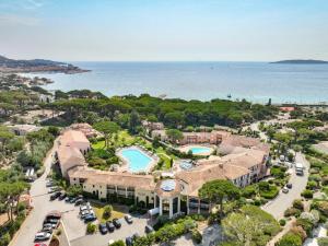an aerial view of a resort with a pool and the ocean at Hôtel Les Jardins De Sainte-Maxime in Sainte-Maxime