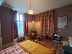 a bedroom with a bed and a chair and a window at Thunder Roadhouse in La Mothe-Saint-Héray