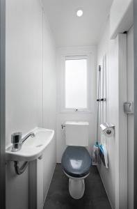 une salle de bains blanche avec toilettes et lavabo dans l'établissement KNAUS Campingpark Eckwarderhörne, à Eckwarderhörne 17 autres photos
