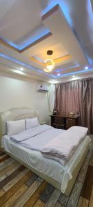 a bedroom with a large white bed and a ceiling at Xiang ge li la Hotel 喀布尔香格里拉酒店 in Kabul
