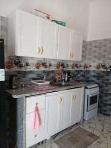 a kitchen with white cabinets and a sink at Villa Mena Luxor in Luxor