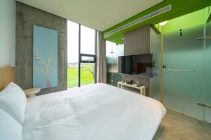 ein Schlafzimmer mit einem großen weißen Bett und einem Fernseher in der Unterkunft 懶懶小日子 in Hou-hou